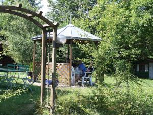 duas pessoas sentadas num gazebo num quintal em Hotel Boarding House Hohenwart em Fuchstal