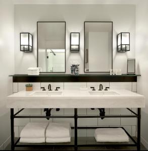 a bathroom with two sinks and a mirror at 21c Museum Hotel Cincinnati in Cincinnati