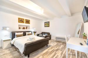 a bedroom with a bed and a couch and a desk at Casa Atanasiu lângă Biserica Neagră în Centrul Istoric in Braşov