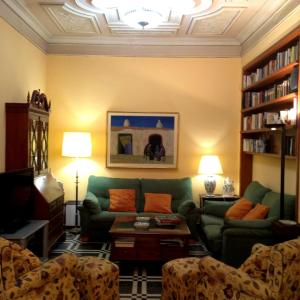 una sala de estar con un sofá verde y estanterías en Casa singular Doña Lola, en Pedreguer