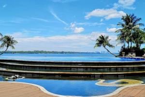 a view of a large body of water with palm trees at Amazing Infinity Sea View Johor Bahru in Johor Bahru