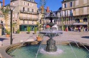 a fountain in the middle of a street with buildings at Ibis Brive Centre in Brive-la-Gaillarde