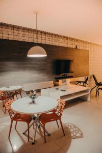 salon z dwoma stołami i telewizorem w obiekcie VEGAS MOTEL w mieście Imperatriz