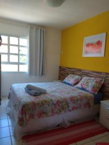 een slaapkamer met een bed met een bloemenbed bij Ponta Negra_Apto Completo in Natal