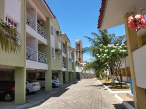 una calle frente a un edificio con palmeras en Ponta Negra_Apto Completo, en Natal