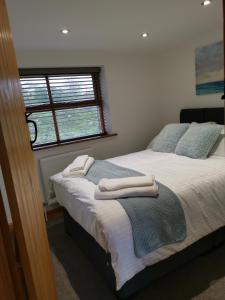 a bedroom with two beds with towels on them at Cwm Farm Cwtch in Merthyr Tydfil