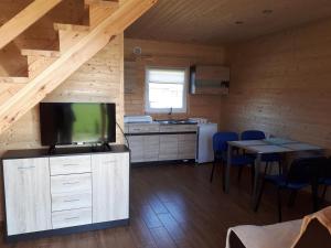a kitchen with a flat screen tv in a cabin at Domki Letniskowe TURKUS in Rewal