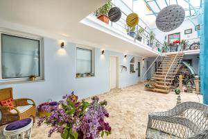 a living room with a staircase and a bunch of plants at Casa Atanasiu lângă Biserica Neagră în Centrul Istoric in Braşov