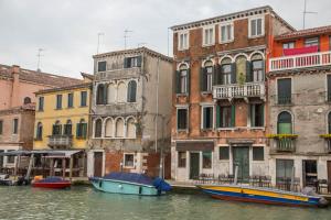 a group of buildings next to a canal with boats at La Colombina in Venice