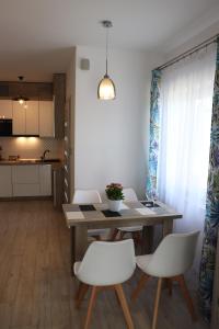 jadalnia ze stołem i białymi krzesłami w obiekcie Apartament Natalia w Busku Zdroju
