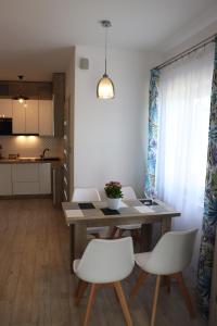 Un comedor con una mesa y sillas blancas. en Apartament Natalia, en Busko-Zdrój