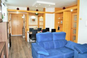 sala de estar con sofá azul y mesa en Apartamento Sun Garden Lloret de Mar, en Lloret de Mar
