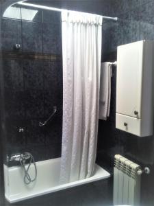 y baño con ducha y cortina de ducha. en Casa de Aldea la Galeria habitación en casa particular, en Póo