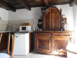 a kitchen with wooden cabinets and a white refrigerator at Babamúzeum 4 fős apartman in Tihany