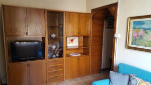 un soggiorno con TV in un armadio in legno di IL TORRETTO a La Spezia