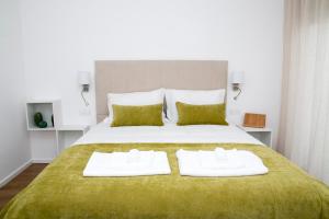 a bedroom with a large bed with two towels on it at Slow House d'Arco in São Brás de Alportel