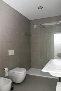 a bathroom with a toilet and a sink and a shower at Slow House d'Arco in São Brás de Alportel