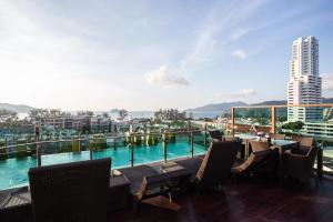 a balcony with a pool and tables and chairs at BAB ALHARA HOTEL in Patong Beach