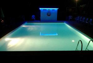 a swimming pool at night with a lit up pool at CAMPING IL MELO in Peveragno