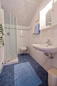 uma casa de banho com um lavatório, um chuveiro e um WC. em Haus Niederweg em Tirolo