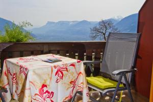 una mesa y una silla en un balcón con montañas en Haus Niederweg, en Tirolo