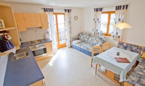 Una cocina y una sala de estar con una mesa y un sofá. en Haus Niederweg, en Tirolo 4 fotos más