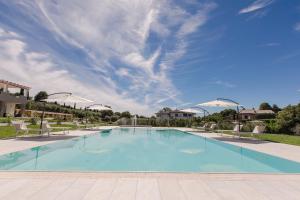 uma piscina com cadeiras e um céu azul em Luxury Apartment Lazise em Lazise