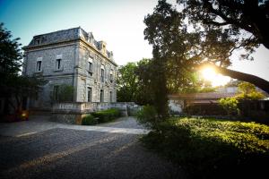 un vieux bâtiment en pierre avec le soleil brillant sur lui dans l'établissement Logis Hôtel Résidence Les Cèdres, à Villeneuve-lès-Avignon