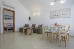 a living room with a table and a couch at Apartmani Srdoč in Baška