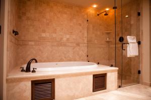 a bathroom with a tub and a glass shower at Pueblo Bonito Montecristo Luxury Villas - All Inclusive in Cabo San Lucas