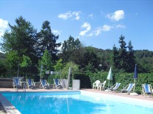 a swimming pool with blue chairs and a group at CAMPING IL MELO in Peveragno