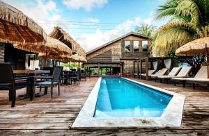 a pool at a resort with chairs and a table at PUR Boutique Cabanas, Adults Only in San Pedro