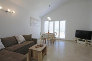 a living room with a couch and a table at Apartmani Srdoč in Baška