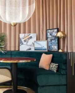 salon z zieloną kanapą i stołem w obiekcie Hôtel Parisianer w Paryżu