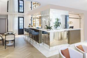 a kitchen with a bar with chairs and a table at Hôtel Parisianer in Paris