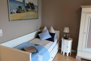 ein kleines Schlafzimmer mit einem Bett und einem Tisch in der Unterkunft Ferienwohnung ROT in Hohenfelde