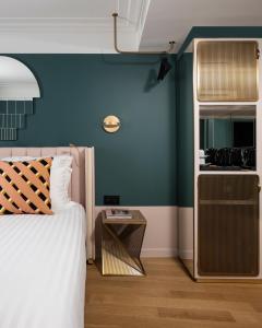 sypialnia z łóżkiem i niebieską ścianą w obiekcie Hôtel Parisianer w Paryżu
