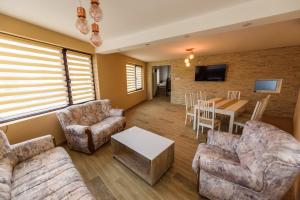 a living room with couches and a table and a dining room at Casa Sky in Orşova