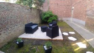 a group of chairs sitting next to a brick wall at La Cotonnerie in Saint-Quentin