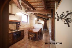 una cucina con tavolo in legno e una sala da pranzo di Hotel Palazzo Meraviglia Albergo diffuso a Corinaldo