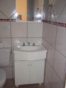 a white bathroom with a sink and a toilet at Posada Iguazu Royal in Puerto Iguazú +30 photos