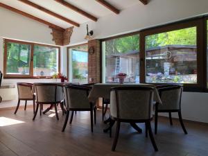 a dining room with tables and chairs and windows at Villa Vodno in Skopje