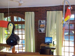 a living room with a bird and a desk with a computer at Posada Iguazu Royal in Puerto Iguazú