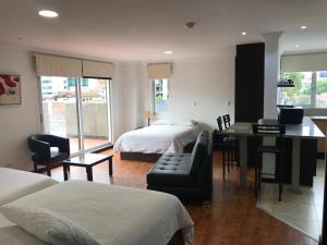 - une chambre d'hôtel avec 2 lits et un bureau dans l'établissement Gaviota Apartments & Suites, à Cuenca