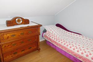ein kleines Schlafzimmer mit einem Bett und einer Kommode in der Unterkunft Pokoje gościnne Barka in Wadowice