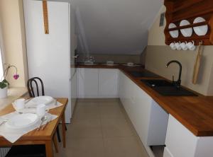 a kitchen with white cabinets and a sink and a table at Pokoje gościnne Barka in Wadowice