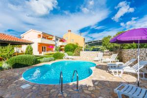 a swimming pool with chairs and an umbrella at Apartmani Albi in Zaton