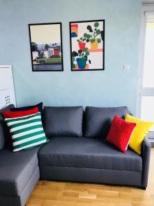 a blue couch with colorful pillows in a living room at Słoneczne Skorosze in Warsaw
