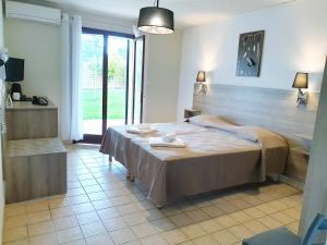 a hotel room with a large bed and a large mirror at Hotel Olmuccio in Sainte-Lucie de Porto-Vecchio