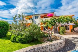 a house with a garden in front of it at Apartmani Albi in Zaton